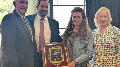Katie Bobowski holding award from the CCAA