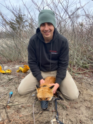 Christian Crosby holding a red fox