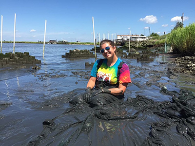 Photo: Brianna Cerione covered in mud - Rutgers Haskin Shellfish Research Lab